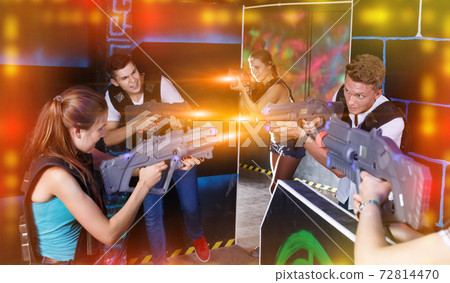 Laser tag players guys and girls playing in teams in dark laser 72814470