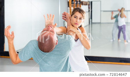 Girl using palm to launch blow in chin during self defence training 72814647