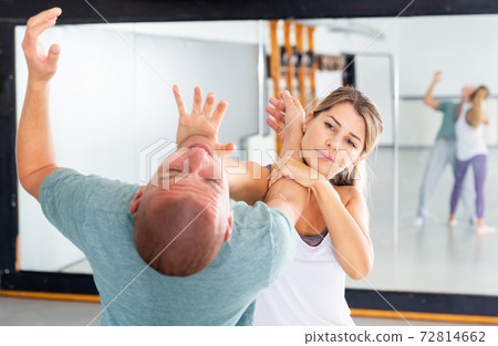 Woman practicing basic palm strike in self defense training Woman practicing basic palm strike in self defense training 72814662