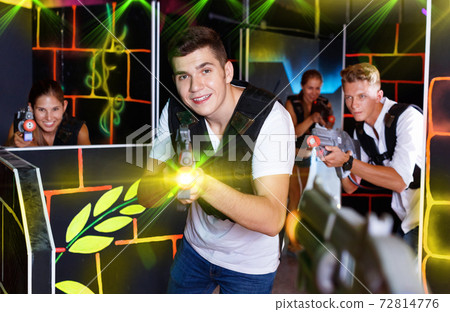 Portrait of excited guy with laser pistol playing laser tag in a Portrait of excited guy with laser pistol playing laser tag in a 72814776