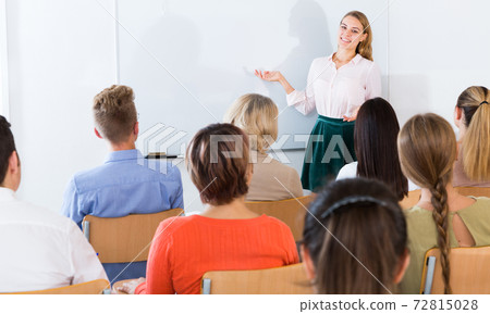 Female student answering in front of student group Female student answering in front of student group 72815028