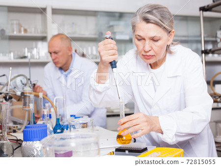 Female biochemists mixing chemicals Female biochemists mixing chemicals 72815055