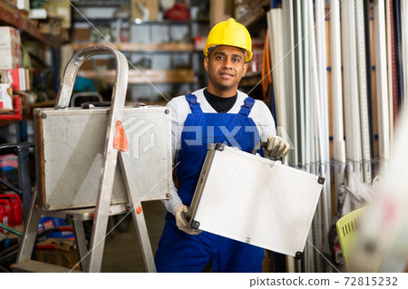 Foreman in protective helmet and overalls with toolbox in hardware store Foreman in protective helmet and overalls with toolbox in hardware store 72815232