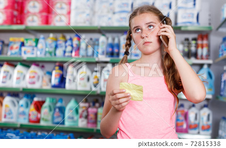 girl with shopping list speaking on smartphone 72815338