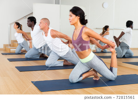 Group of sporty people practicing yoga positions during training 72815561
