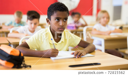 Diligent african american tween boy studying in classroom 72815562