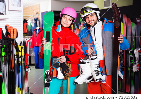 Man and woman standing with purchased ski equipment in shop Man and woman standing with purchased ski equipment in shop 72815632