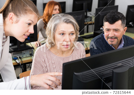 Young female coach giving computer lessons Young female coach giving computer lessons 72815644