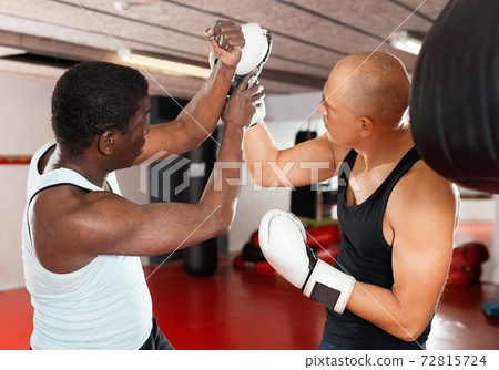 African american trainer teaches man in boxing 72815724