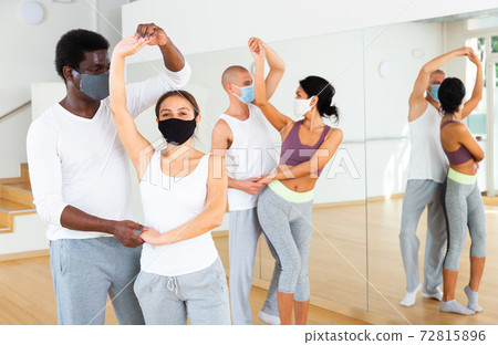 Group of multinational people in protective masks practicing dance techniques Group of multinational people in protective masks practicing dance techniques 72815896