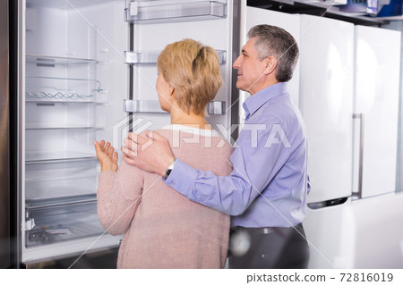 Lovely mature married couple choose for themselves refrigerator Lovely mature married couple choose for themselves refrigerator 72816019