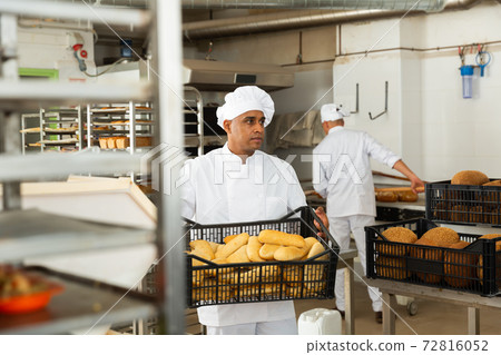 Baker with box with baguettes in bakery Baker with box with baguettes in bakery 72816052