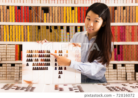 Asian girl holding palette of hair dye samples Asian girl holding palette of hair dye samples 72816072