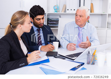 Employees are working together at computer Employees are working together at computer 72816249