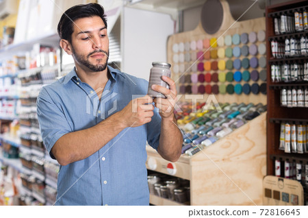Serious young man looking instruction on paint Serious young man looking instruction on paint 72816645