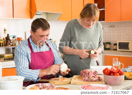 Senior woman and son-in-law preparing dinner Senior woman and son-in-law preparing dinner 72817067