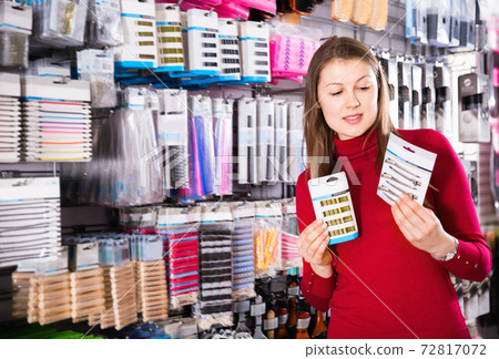 Young woman is choosing new hair clips in hair care store. Young woman is choosing new hair clips in hair care store. 72817072
