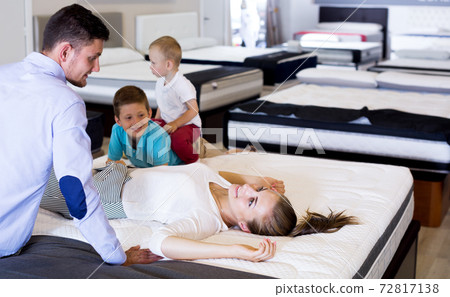 Girl with her family testing quality of mattress Girl with her family testing quality of mattress 72817138