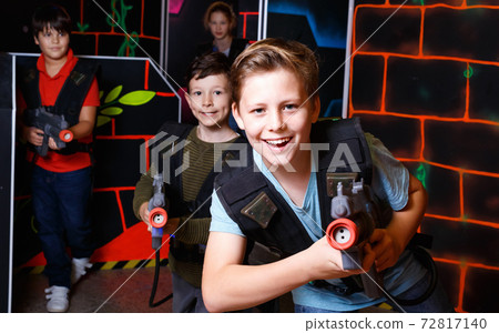 Portrait of preteen boy with laser gun having fun on dark lasertag arena Portrait of preteen boy with laser gun having fun on dark lasertag arena 72817140