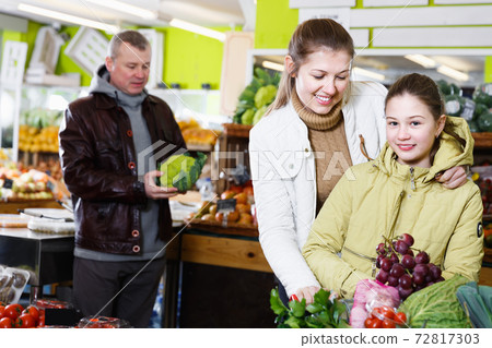 Smiling woman and child choosing for fresh delicious fruits 72817303