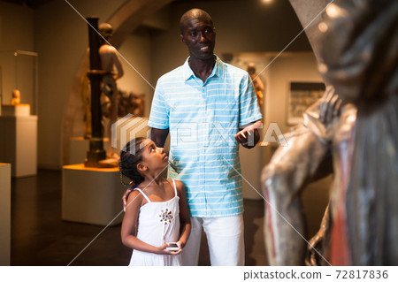 Man and his daughter looking at medieval art 72817836