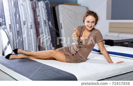 Portrait of happy attractive girl delighted with mattresses Portrait of happy attractive girl delighted with mattresses 72817838