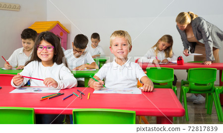 Happy pupils working in classroom 72817839