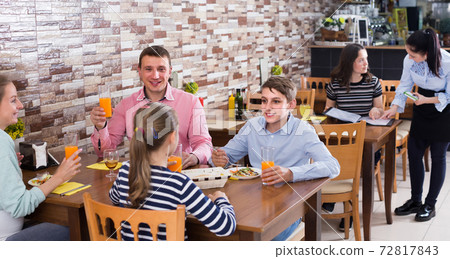 family with teenage children enjoying meal in cafe family with teenage children enjoying meal in cafe 72817843