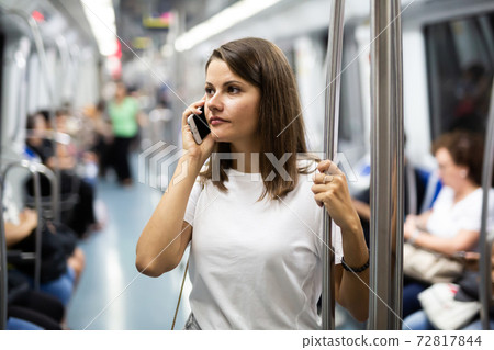 Female talking on smartphone in subway car Female talking on smartphone in subway car 72817844