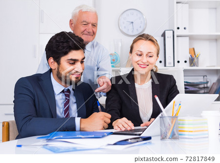 Managers are demonstrating reports on laptop to mature boss Managers are demonstrating reports on laptop to mature boss 72817849