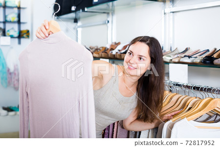 happy woman choosing new blouse in apparel shop happy woman choosing new blouse in apparel shop 72817952