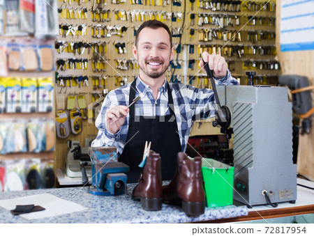 Worker demonstrating newly shaped key Worker demonstrating newly shaped key 72817954