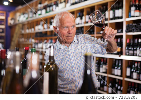 Senior male tasting wines in winery 72818205