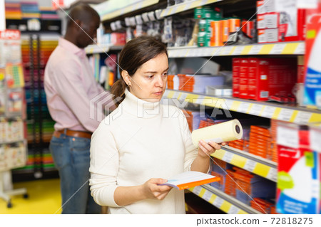 Young woman choosing different office supplies 72818275