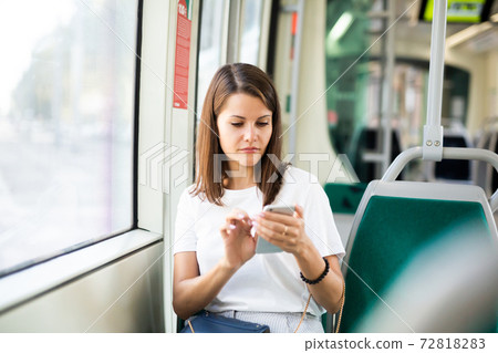 Girl using smartphone in public transport Girl using smartphone in public transport 72818283