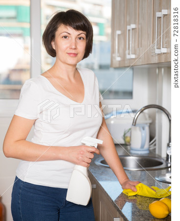 Cheerful woman doing housework Cheerful woman doing housework 72818316