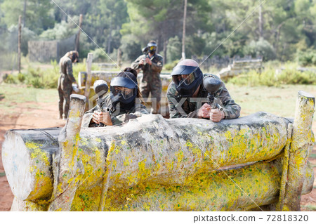 Paintball players playing outdoors Paintball players playing outdoors 72818320
