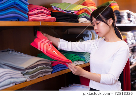 Girl choosing polo shirt 72818326