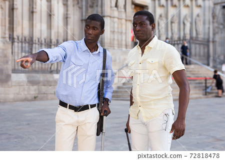 Positive african american men talking and pointing finger at the street Positive african american men talking and pointing finger at the street 72818478