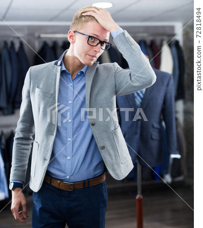 costumer in the glasses trying jacket in the shop 72818494