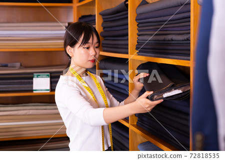 Female seller of fabric shop showing textiles 72818535