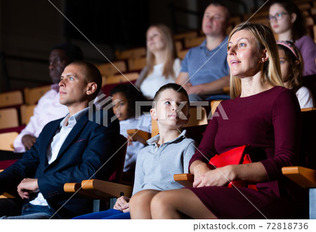 Family of theatergoers with preteen son watching performance in theater 72818736