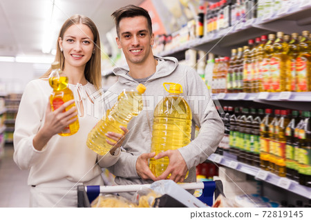 Smiling man and woman choosing olive oil Smiling man and woman choosing olive oil 72819145