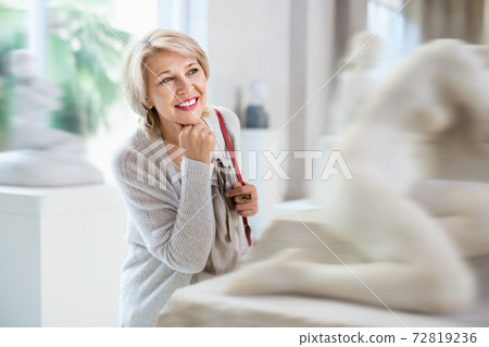 Adult female looking at artwork sculpture in the museum indoors 72819236
