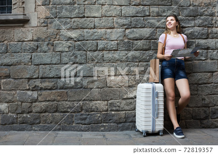 Traveling female standing on wall background 72819357
