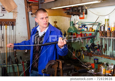 Lubricating and cleaning the barrel of rifle in gun workshop Lubricating and cleaning the barrel of rifle in gun workshop 72819616