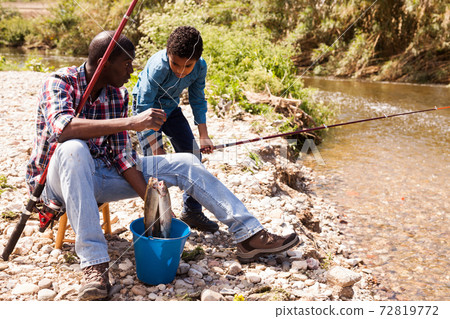 Man and boy with fish catch Man and boy with fish catch 72819772