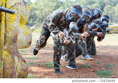 Portrait of team of adult people playing on paintball battlefield outdoor 72819849