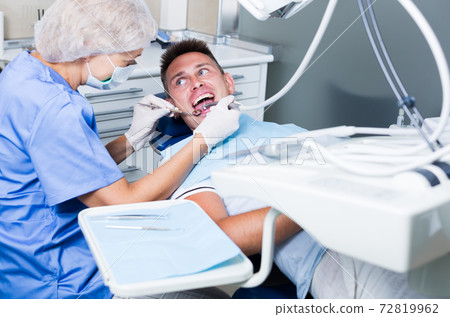 Male patient getting dentist treatment Male patient getting dentist treatment 72819962