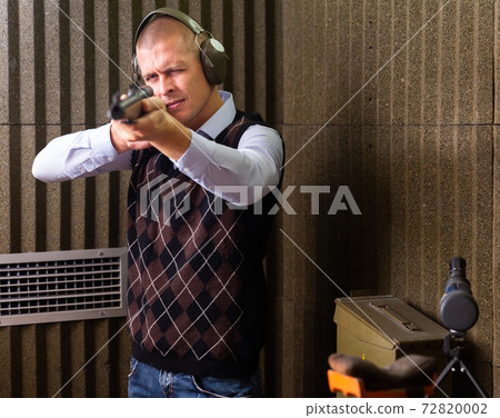 Man shoots semi-automatic rifle at shooting range Man shoots semi-automatic rifle at shooting range 72820002